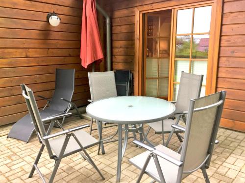 een witte tafel en stoelen op een patio bij Strandschlösschen Sellin - Haushälfte 1 in Ostseebad Sellin