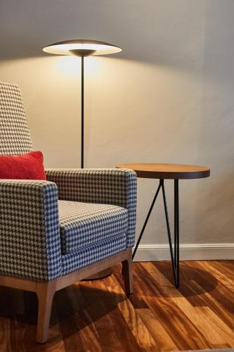 a room with a chair and a table and a lamp at Hotel Silken Palacio Uribarren in Lekeitio