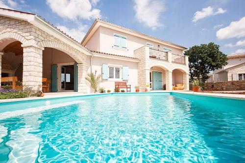 a large swimming pool in front of a house at Villa Krmed in Krmed
