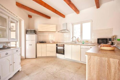 a kitchen with white cabinets and a white refrigerator at Villa Krmed in Krmed