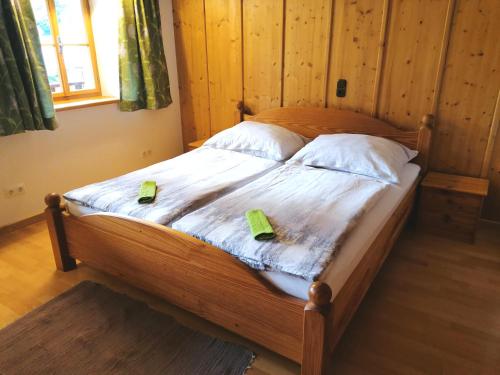 a wooden bed with two green towels on it at Hoamatleuchten in Pettenbach