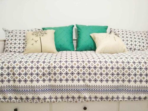 a couch with pillows and a blanket on it at LA CASITA DEL JARDiN in Villaverde de Arriba