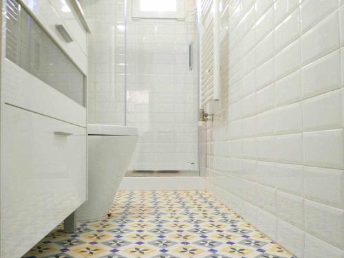 baño con aseo y suelo de baldosa. en LA CASITA DEL JARDiN, en Villaverde de Arriba