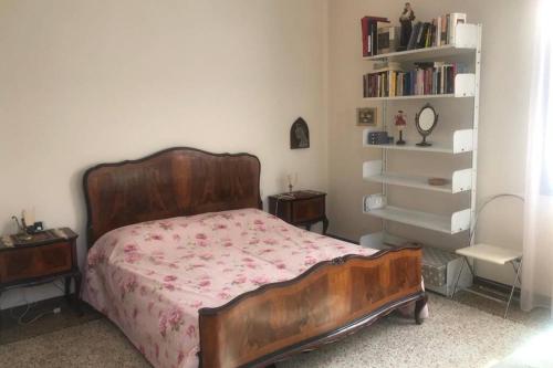 sypialnia z łóżkiem i półką na książki w obiekcie A Casa di Claudia w Wenecji