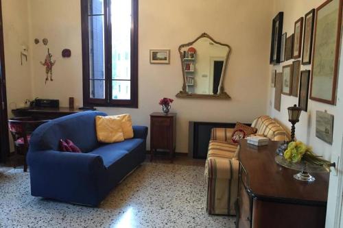 a living room with a blue couch and a table at A Casa di Claudia in Venice