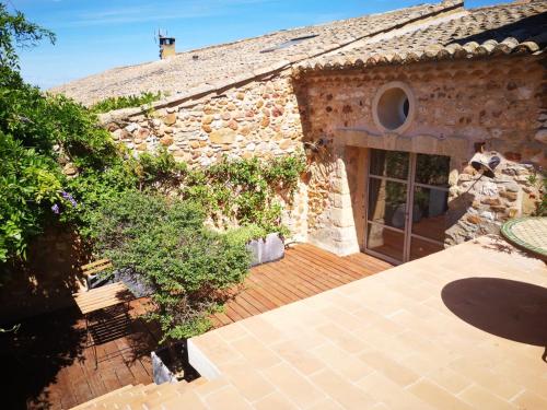 vista esterna di un edificio in pietra con patio di Mas Luis Alvarez a La Capelle-et-Masmolène