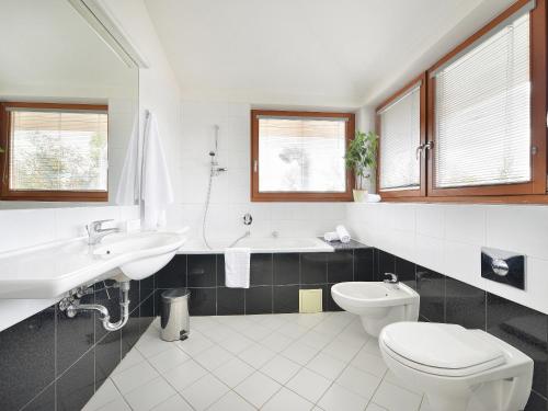 a bathroom with a sink and a toilet and a tub at EA Hotel Populus in Prague