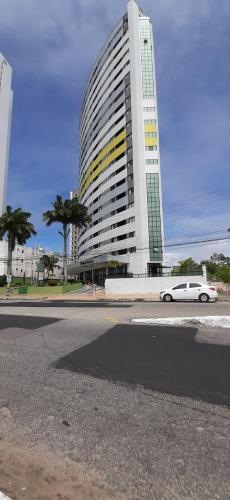 a white car parked in front of a large building at Natal Plaza requinte, conforto e vista para o mar in Natal