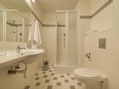 a bathroom with a toilet and a sink and a shower at EA Hotel Populus in Prague