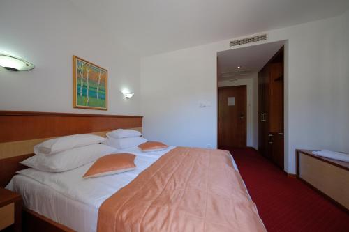 a bedroom with a large white bed with orange pillows at Motel Mujanic Sarajevo in Sarajevo