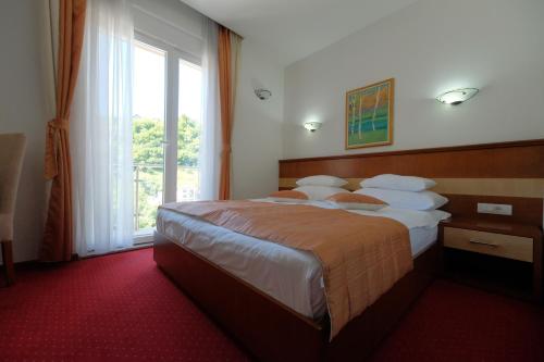 una camera d'albergo con un grande letto e una finestra di Motel Mujanic Sarajevo a Sarajevo
