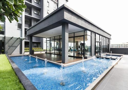 a building with a swimming pool with water fountains at NORDIC Geniehome2BR1studio Free 90mbps WIFI and Carpark at Utropolis Suite Shah Alam in Shah Alam