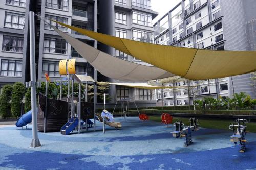 a playground in front of a building with swings at NORDIC Geniehome2BR1studio Free 90mbps WIFI and Carpark at Utropolis Suite Shah Alam in Shah Alam