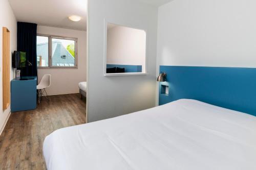 a bedroom with a white bed and white walls at Ténéo Apparthotel Bordeaux Gare Saint Jean in Bordeaux