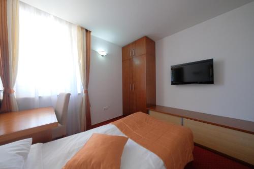 a hotel room with a bed and a flat screen tv at Motel Mujanic Sarajevo in Sarajevo