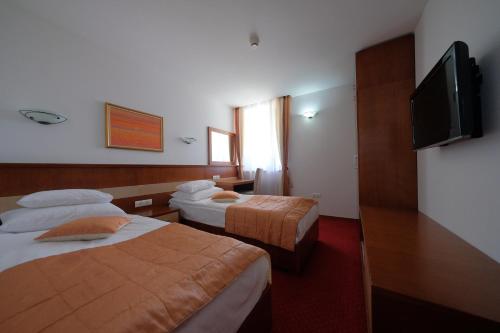 a hotel room with two beds and a flat screen tv at Motel Mujanic Sarajevo in Sarajevo