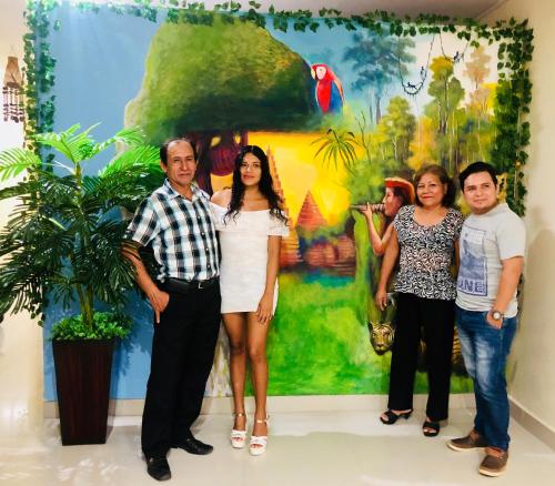 a group of people standing in front of a painting at El Paititi Hotel in Iquitos
