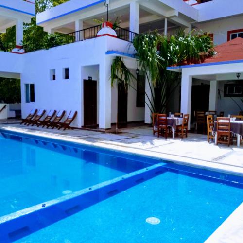 a villa with a swimming pool and a restaurant at Hotel D Abril in Santa Cruz Huatulco