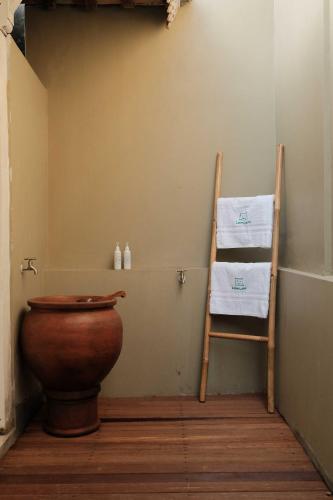 NgaglikにあるUbu Villa Donolayan - 4 Bedrooms Villa in Yogyakartaのバスルーム(トイレ、木製の椅子付)