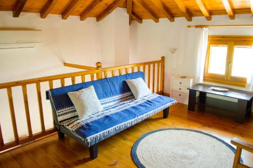 a living room with a blue couch and a table at Kalokairi Cottage in Skopelos Town