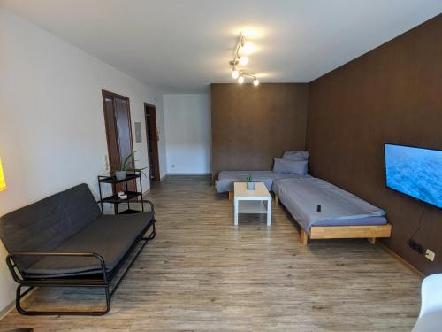 1 dormitorio con cama, sofá y TV en ideale Messe/Airport Wohnung 15min Fahrtweg en Kirchheim unter Teck