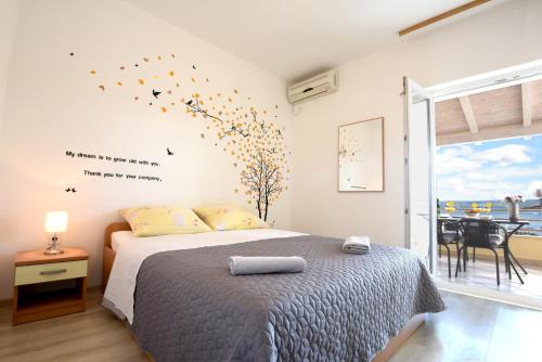 ein Schlafzimmer mit einem Bett mit Vögeln an der Wand in der Unterkunft Apartmani Joško Duće - Omiš in Duće