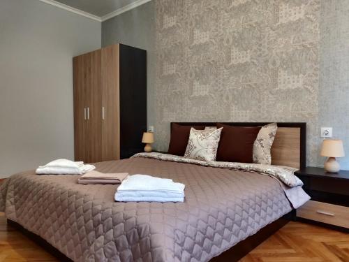 - une chambre avec un grand lit et des serviettes dans l'établissement White Apartment, à Kazanlak