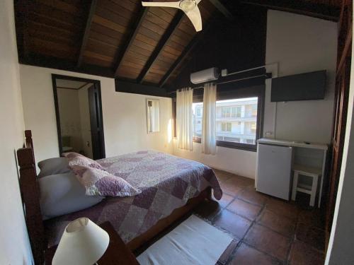a bedroom with a bed and a window at Pousada Morada Da Prainha in Torres