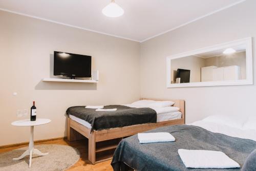 a bedroom with two beds and a flat screen tv at Sopot Host Stacja in Sopot