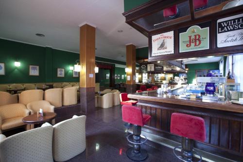 un bar dans un restaurant avec des chaises rouges dans l'établissement Playalinda, à Roquetas de Mar