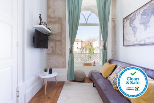 a living room with a couch and a window at Host Wise - Charming Flat with Netflix - River View in Porto