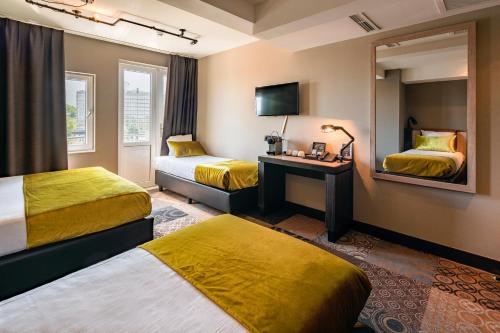 a hotel room with two beds and a mirror at The Alfred Hotel in Amsterdam