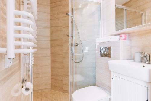 ein Bad mit einer Dusche, einem WC und einem Waschbecken in der Unterkunft Sopot Host Stacja in Sopot