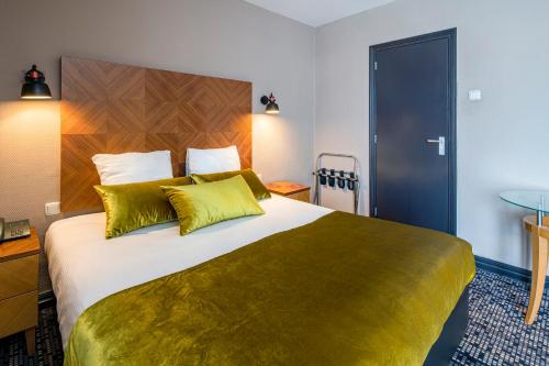 a hotel room with a large bed with yellow pillows at The Alfred Hotel in Amsterdam