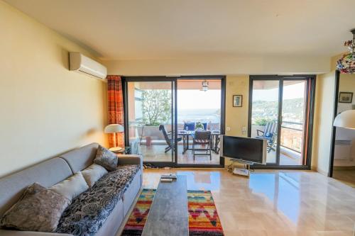 un salon avec un canapé et une télévision dans l'établissement RESIDENCE DU CAP AP2027 - Villefranche-sur-Mer, by Riviera Holiday Homes, à Villefranche-sur-Mer