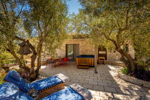 a patio with a table and chairs and trees at Anthemion Suites and Villas in Nafplio