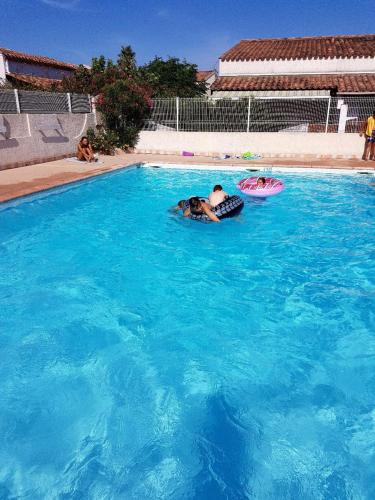 une personne dormant dans une piscine avec un frisbee dans l'établissement Villa au calme à 200m de la plage de Rochelongue, au Cap d'Agde