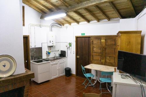 a kitchen with a table and a counter top at Casa da Corriça - Alojamento Local in Negreda