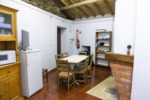 eine Küche und ein Esszimmer mit Tisch und Stühlen in der Unterkunft Casa da Corriça - Alojamento Local in Negreda