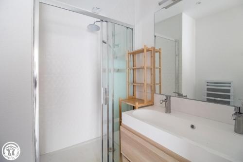 een badkamer met een bad en een glazen douche bij Gîte de Granit GRIS in Besse-et-Saint-Anastaise