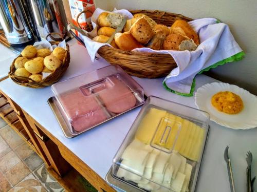 a table with a basket of bread and a plate of food at Pousada Rancho dos Ipês in Alto Paraíso de Goiás