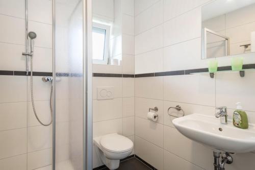 ein weißes Bad mit einem WC und einem Waschbecken in der Unterkunft Ferienwohnung Eyrich Eg in Lindau