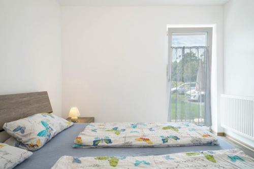 ein Bett mit zwei Kissen darauf in einem Schlafzimmer in der Unterkunft Ferienwohnung Eyrich Eg in Lindau