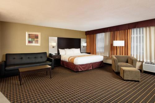 Habitación de hotel con cama y sofá en Quality Inn & Suites Downtown Windsor, ON, Canada en Windsor