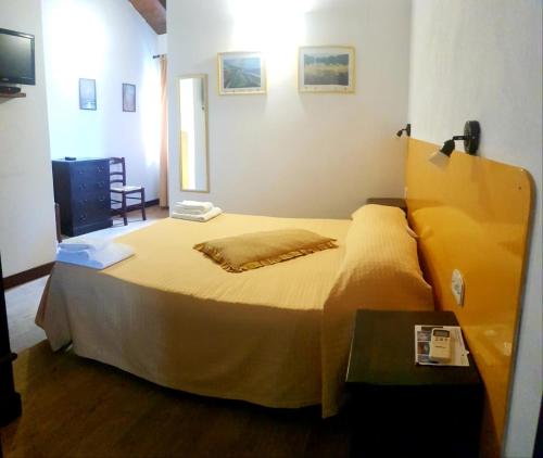 a bedroom with a bed with a yellow bedspread at Agriturismo Feudo Gagliardi in Caulonia