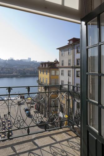 a balcony with a view of the water and buildings at PortoSense Ribeira in Porto