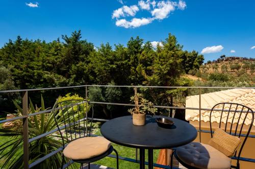 a table and chairs on a balcony with a view at Anthemion Suites and Villas in Nafplio