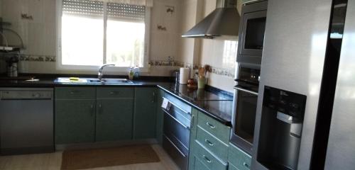 a kitchen with green cabinets and a sink at Villa Casa Kenaz in El Campello