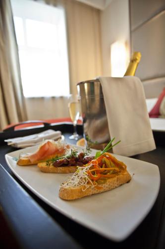 a white plate with two slices of pizza on a table at Savoy Hotel in Buenos Aires
