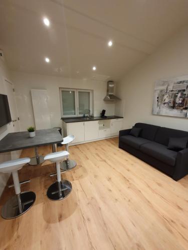 a living room with a black couch and a table at Brussels North - Pajot Apartments in Wemmel